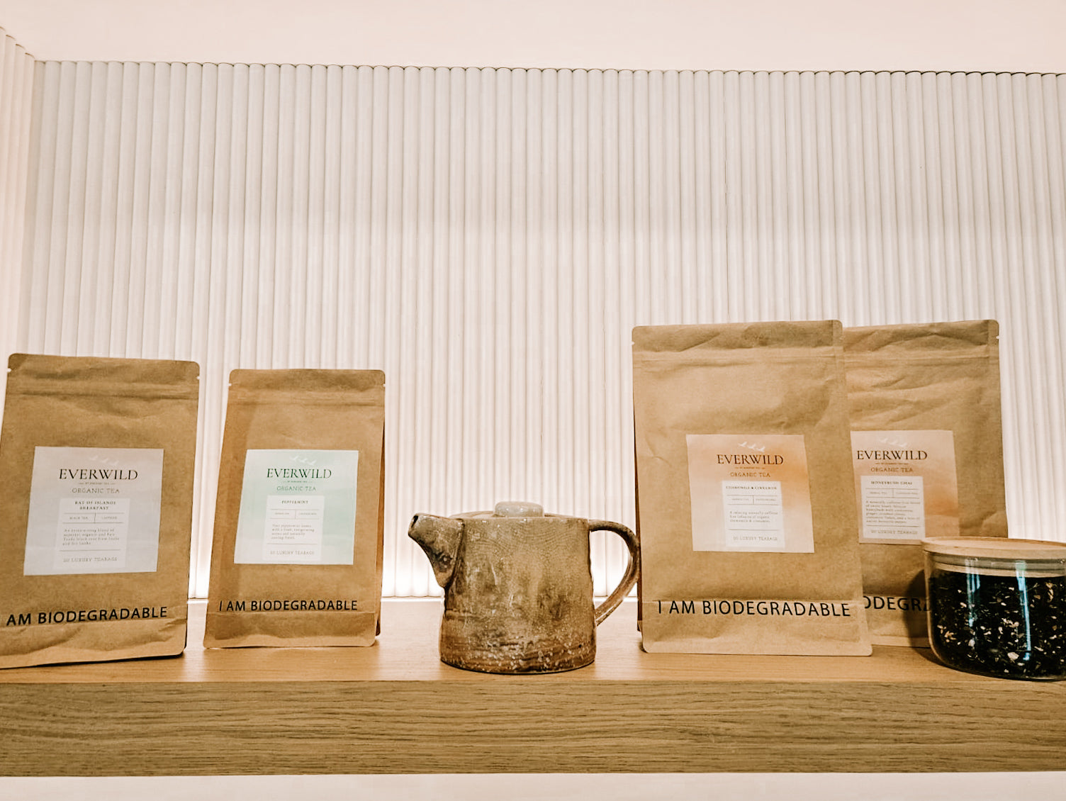 Everwild biodegradable tea pouches arranged with a ceramic teapot
