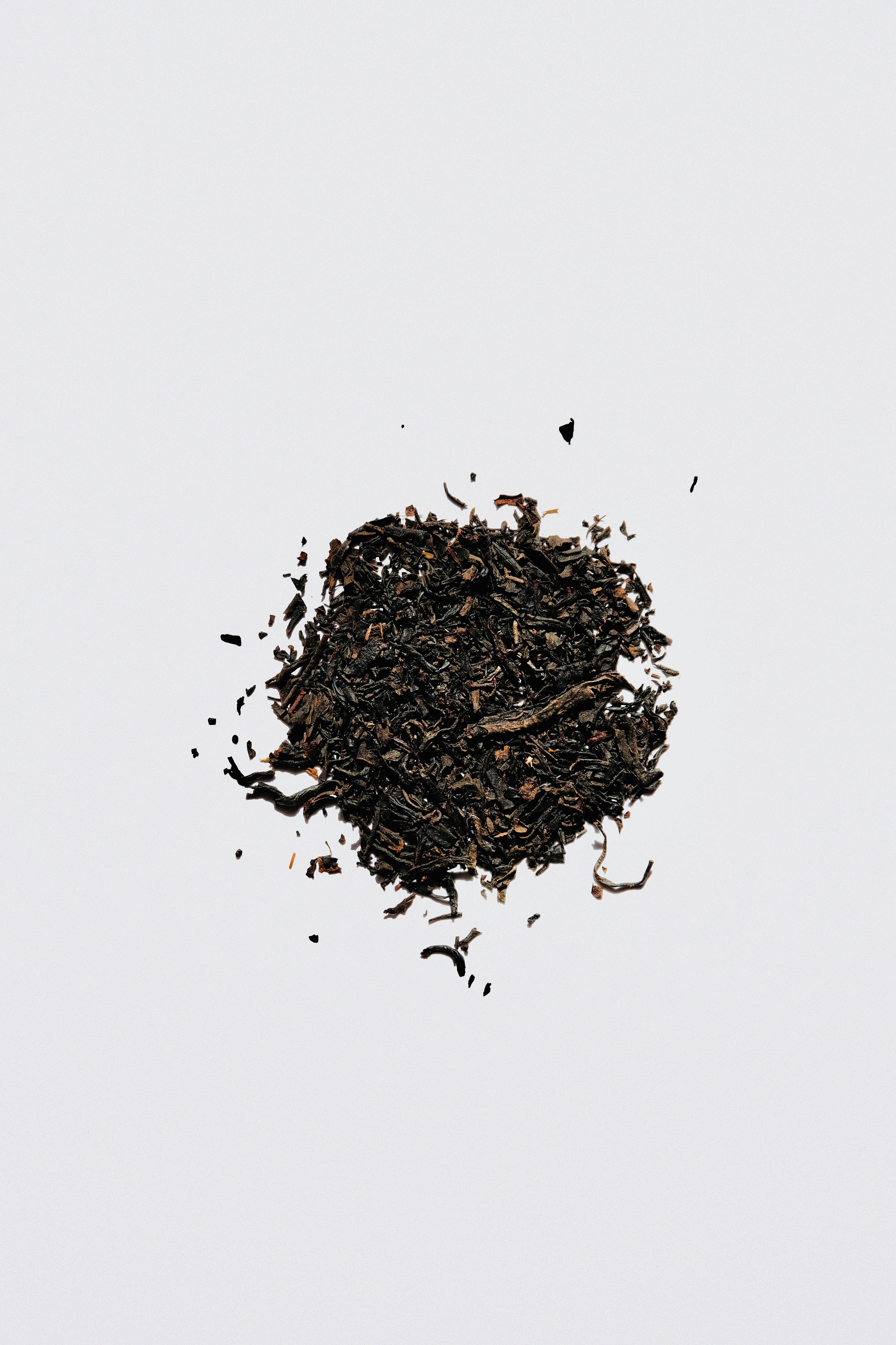 Loose black tea leaves on a clean white background