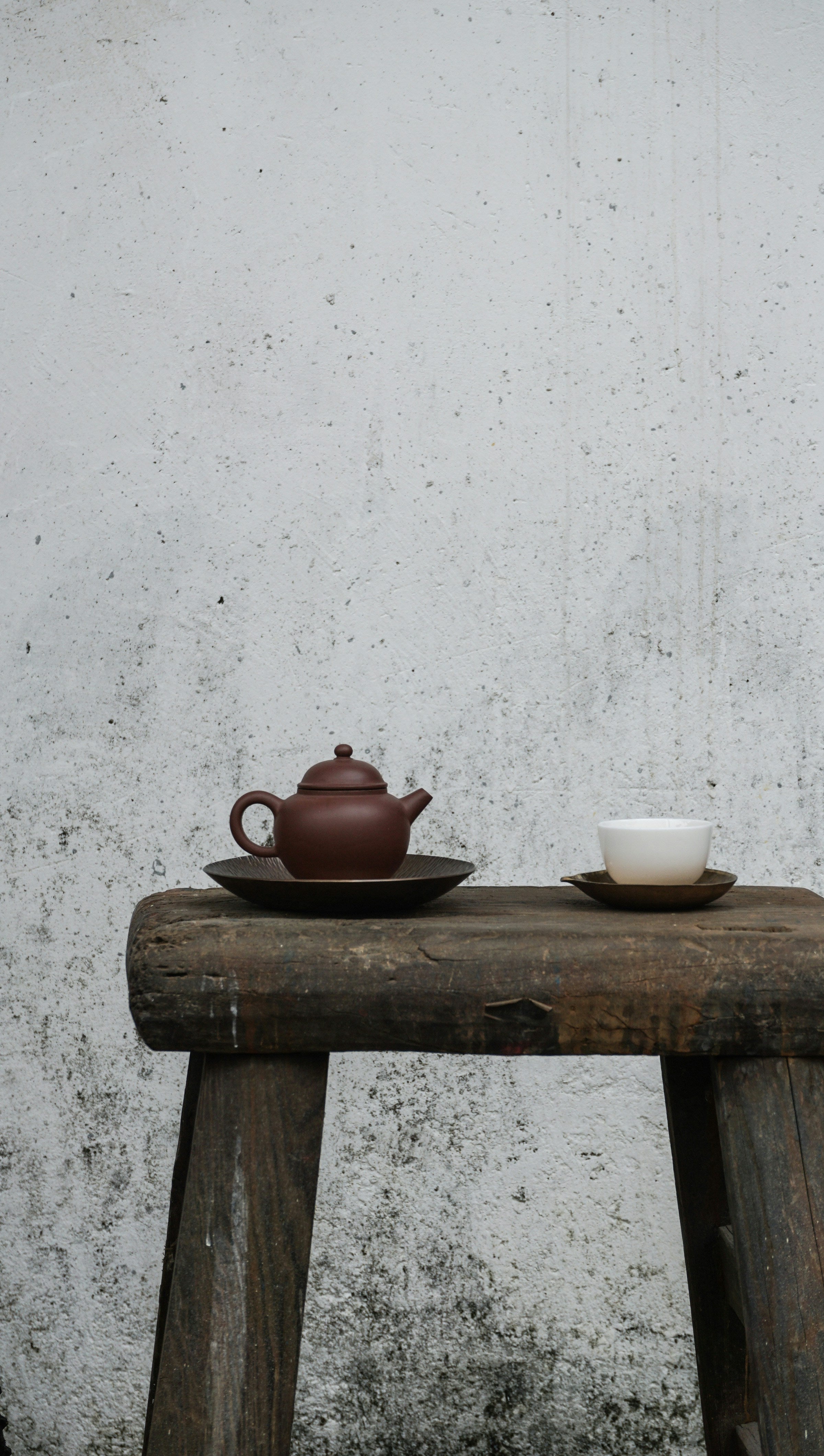 Minimal ceramic teapot and tea cup on a rustic table